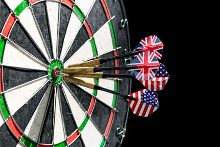 Metal darts have hit the red bullseye on a dart board. Darts Game. Darts arrow in the target center darts in bull's eye close up. Success hittingの写真素材