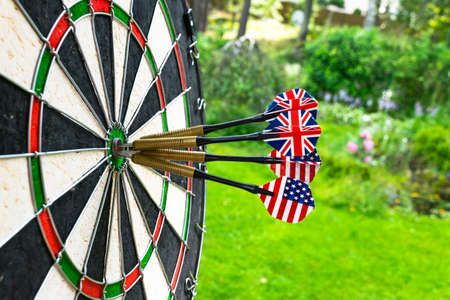 Metal darts have hit the red bullseye on a dart board. Darts Game. Darts arrow in the target center...