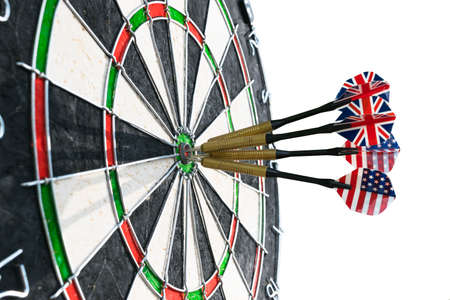 Metal darts have hit the red bullseye on a dart board. Darts Game. Darts arrow in the target center darts in bull's eye close up. isolated on white background.Success hittingの写真素材