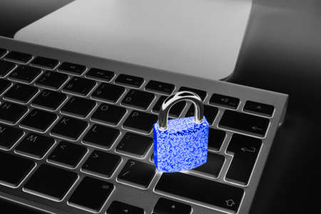 Locked computer safe from virus or malware attack. Laptop computer being protected from online cyber crime and hacking. Computer security concept with a padlock on a keyboard. protection various risksの写真素材