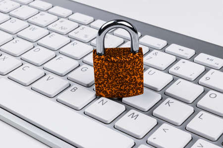 Locked computer safe from virus or malware attack. Laptop computer being protected from online cyber crime and hacking. Computer security concept with a padlock on a keyboard.  protection various risksの写真素材