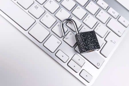 Locked computer safe from virus or malware attack. Laptop computer being protected from online cyber crime and hacking. Computer security concept with a padlock on a keyboard. protection various risksの写真素材