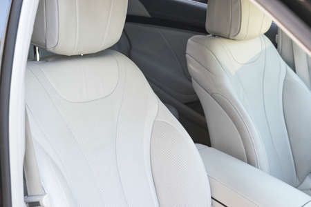 White leather interior of the luxury modern car. Leather comfortable white seats and multimedia. exclusive wood and metal decoration. Modern car interior details. の写真素材