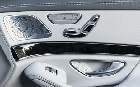 Door handle with Power seat control buttons of a luxury passenger car. White leather interior of the luxury modern car. Modern car interior detailsの写真素材