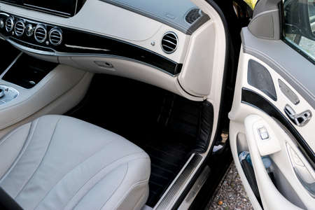 White leather interior of the luxury modern car. Leather comfortable white seats and multimedia. Steering wheel and dashboard. Automatic gear shift. Car interior detailsの写真素材