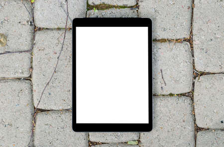 Tablet computer on grey stone background. Isolated white screen with copy space. Empty space for text. Empty blank screen.の写真素材