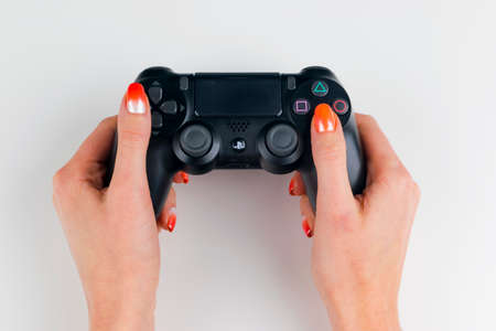 Sankt-Petersburg, Russia, September 24, 2017: Sony PlayStation 4 dualshock game controller in gamers hand on white background studio shot.のeditorial素材