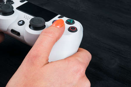 Sankt-Petersburg, Russia, September 24, 2017: Sony PlayStation 4 dualshock game controller in gamers hand on white background studio shot.のeditorial素材