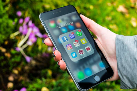 Sankt-Petersburg, Russia, October 13, 2017: iphone 6 plus with icons of social media in girl hands. Smartphone life style smartphone. Starting social media app.のeditorial素材