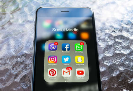 Sankt-Petersburg, Russia, October 13, 2017: iphone 6 plus with icons of social media on screen on green wooden table. Smartphone life style smartphone. Starting social media app.のeditorial素材