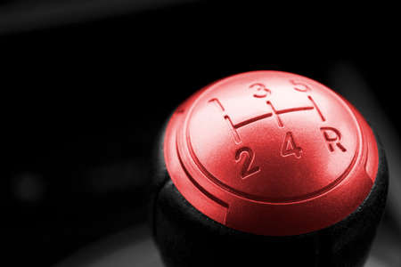 Close up view of a red gear lever, manual gearbox, car interior details