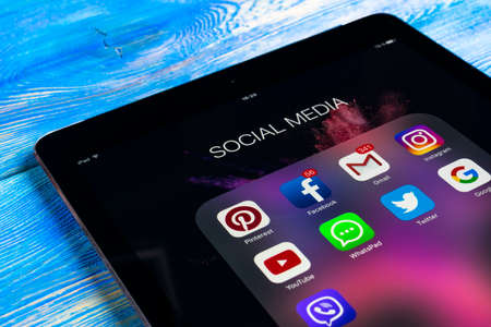 Sankt-Petersburg Russia November 11, 2017: tab  on wooden table with icons of social media facebook, instagram, twitter,  application on screen. Tablet Starting social media app.のeditorial素材