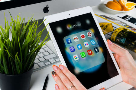 Sankt-Petersburg, Russia, November 14, 2017: Woman Hands using iPad pro with icons of social media facebook, instagram, twitter, google application on screen. Smartphone Starting social media app.のeditorial素材