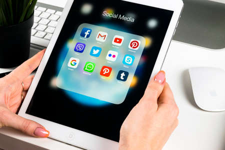 Sankt-Petersburg, Russia, November 14, 2017: Woman Hands using iPad pro with icons of social media facebook, instagram, twitter, google application on screen. Smartphone Starting social media app.のeditorial素材