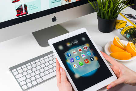 Sankt-Petersburg, Russia, November 14, 2017: Woman Hands using iPad pro with icons of social media facebook, instagram, twitter, google application on screen. Smartphone Starting social media app.のeditorial素材