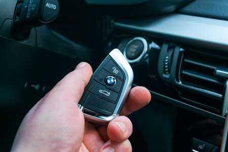 Sankt-Petersburg, Russia, November 16, 2017: BMW X5 F15 start car key in a male hand near start/stop push button. Modern car interior details. The key to starting the engine of the carのeditorial素材