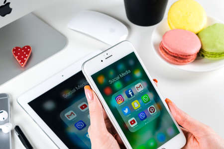 Sankt-Petersburg, Russia, November 21, 2017: Woman Hands using iphone 7 with icons of social media facebook, instagram, twitter, google application on screen. Smartphone Starting social media app.のeditorial素材