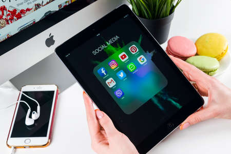 Sankt-Petersburg, Russia, November 21, 2017: Woman Hands using iPad pro with icons of social media facebook, instagram, twitter, google application on screen. Smartphone Starting social media app.のeditorial素材