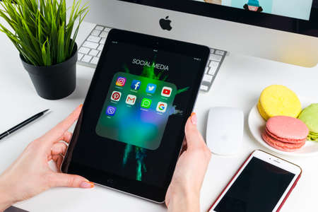 Sankt-Petersburg, Russia, November 14, 2017: Woman Hands using iPad pro with icons of social media facebook, instagram, twitter, google application on screen. Smartphone Starting social media app.のeditorial素材