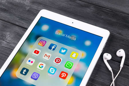 Sankt-Petersburg Russia November 23, 2017: Apple iPad Pro on wooden table with icons of social media facebook, instagram, twitter, snapchat application on screen. Tablet Starting social media app.のeditorial素材