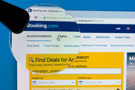 Sankt-Petersburg Russia December 7, 2017: Homepage of the official website for Booking.com on Apple iMac monitor screen under magnifying glass. Biggest online website for booking hotel rooms online.のeditorial素材