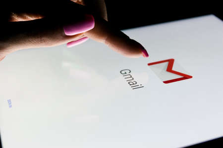 Sankt-Petersburg, Russia, December 21, 2017:  A woman's hand is touching screen on tablet computer iPad Pro at night with open Google Gmail application. Gmail is a free e-mail service provided by Google.のeditorial素材