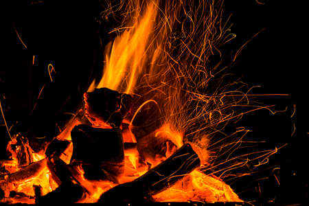 Burning firewood in the fireplace close up, BBQ fire, charcoal background. Charcoal fire with sparks