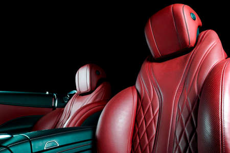 Modern Luxury car inside. Interior of prestige modern car. Comfortable leather seats. Red perforated leather cockpit with isolated Black background. Modern car interiorの写真素材