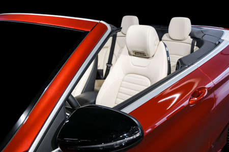 Modern Luxury car inside. Interior of prestige modern car. Comfortable leather seats. White perforated leather cockpit with isolated Black background. Modern car interior detailsの写真素材