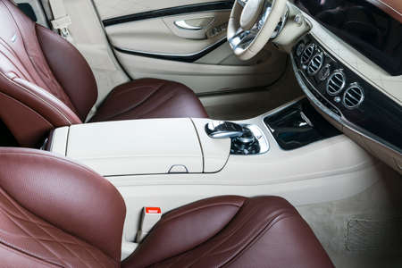 Modern Luxury car inside. Interior of prestige modern car. Comfortable leather seats. Red and white perforated leather cockpit. Steering wheel and dashboard. automatic gear stick shift. Car interiorの写真素材