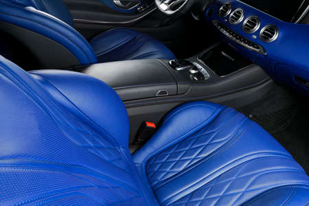 Modern Luxury car inside. Interior of prestige modern car. Comfortable leather seats. Blue perforated leather cockpit. Steering wheel and dashboard. automatic gear stick shift. Car interiorの写真素材