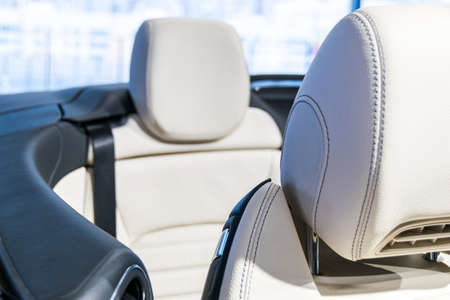 Modern luxury car perforated stitched white leather interior.Part of leather car seat details. Modern car white leather interior details.の写真素材