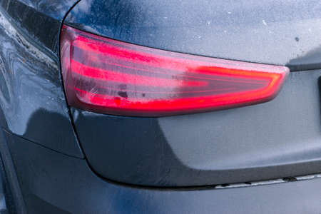 Back view of a very dirty car. Fragment of a dirty SUV. Dirty rear lights, wheel and bumper of the off-road car with swamp splashes on a side panelの写真素材