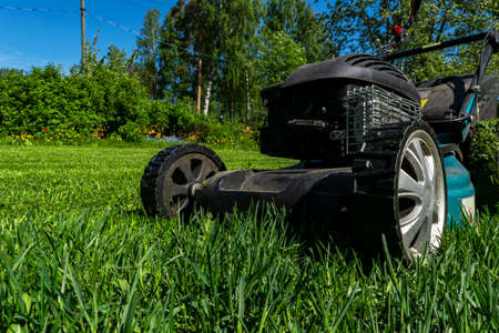 Mowing lawns, Lawn mower on green grass, mower grass equipment, mowing gardener care work tool, close up view, sunny day. Soft lightningの写真素材