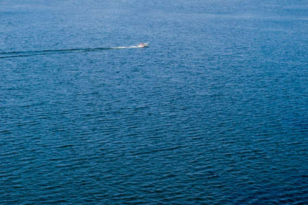 Aerial view of speeding boat in sea. Speed boat at sea. View from above. Speedboat floating in a...