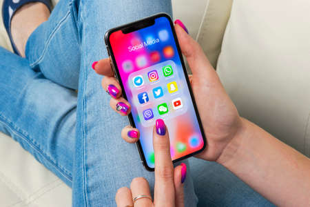 Sankt-Petersburg, Russia, May 30, 2018: Apple iPhone X in woman hands with icons of social media...