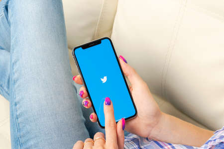 Sankt-Petersburg, Russia, May 30, 2018: Twitter application icon on Apple iPhone X smartphone screen close-up in woman hands. Twitter app icon. Social media icon. Social networkのeditorial素材