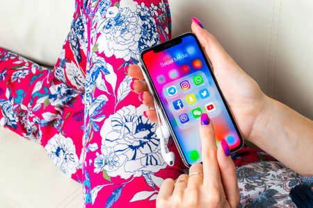 Sankt-Petersburg, Russia, June 8, 2018: Apple iPhone X in woman hands with icons of social media facebook, instagram, twitter, snapchat application on screen. Social media icons. Social network.のeditorial素材