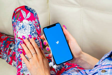 Sankt-Petersburg, Russia, June 8, 2018: Twitter application icon on Apple iPhone X smartphone screen close-up in woman hands. Twitter app icon. Social media icon. Social networkのeditorial素材