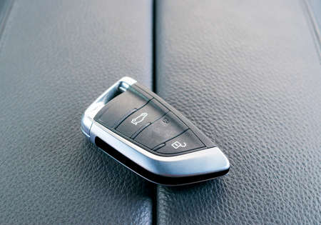 Closeup inside vehicle of wireless key ignition. Start engine key. Car key remote in black...