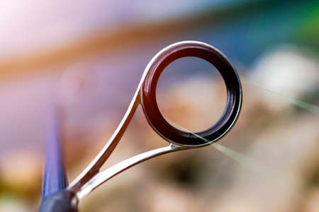 Fishing rod spinning ring with the line close-up. Fishing rod. Rod rings Selective focus and shallow Depth of field .Fishing tackle. Fishing spinning reel.の写真素材