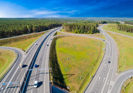 Aerial view of highway in city. Cars crossing interchange overpass. Highway interchange with...