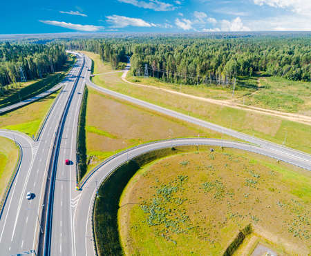 Aerial view of highway in city. Cars crossing interchange overpass. Highway interchange with...