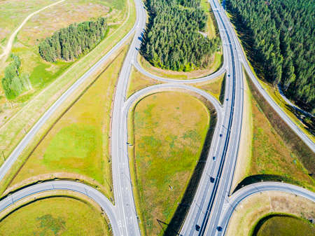Aerial view of highway in city. Cars crossing interchange overpass. Highway interchange with...