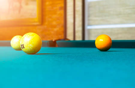 Billiard table close up. Playing billiard. Billiards balls and cue on green billiards table....