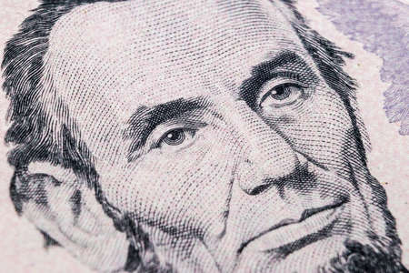 Close up view Portrait of Abraham Lincoln on the one five dollar bill. Background of the money. 5 dollar bill with Abraham Lincoln eyes macro shot. Money background. Face portraitのeditorial素材