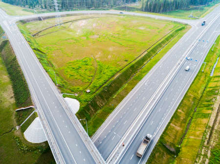 Aerial view of highway in city. Cars crossing interchange overpass. Highway interchange with...