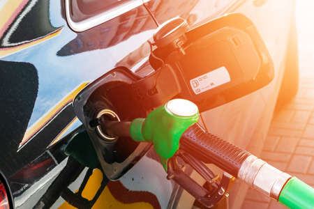 Refueling the car at a gas station fuel pump. Man driver hand refilling and pumping gasoline oil the car with fuel at he refuel station. Car refueling on petrol station. Fuel pump at stationのeditorial素材