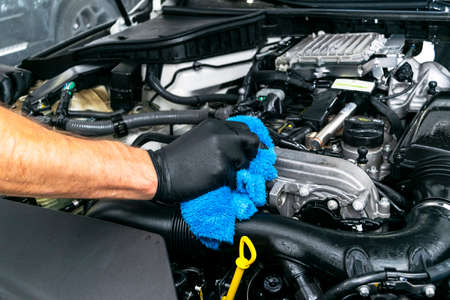 A man cleaning car with microfiber cloth. Car detailing. Valeting concept. Selective focus. Car detailing. Cleaning with sponge. Worker cleaning. Microfiber and cleaning solution to cleanの写真素材
