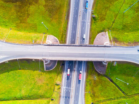 Aerial view of highway in city. Cars crossing interchange overpass. Highway interchange with traffic. Aerial bird's eye photo of highway. Expressway. Road junctions. Car passing. Top view from above.の写真素材
